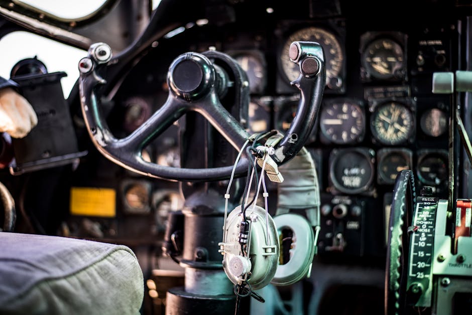Close-up of a vintage aircraft cockpit showing controls, dials, and headphones in rich detail.